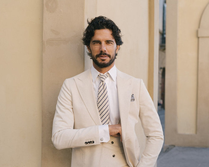 Man in a beige suit standing in an archway