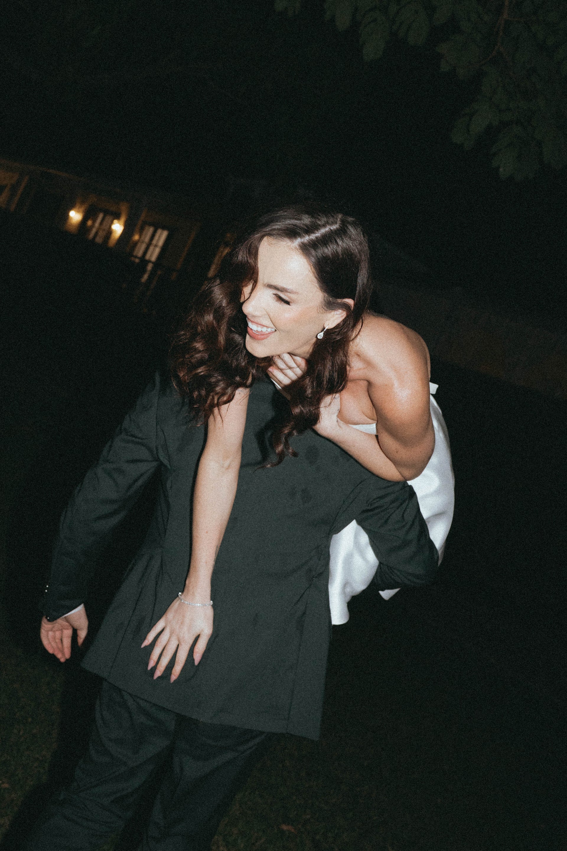 Two people embracing at night with a dark background