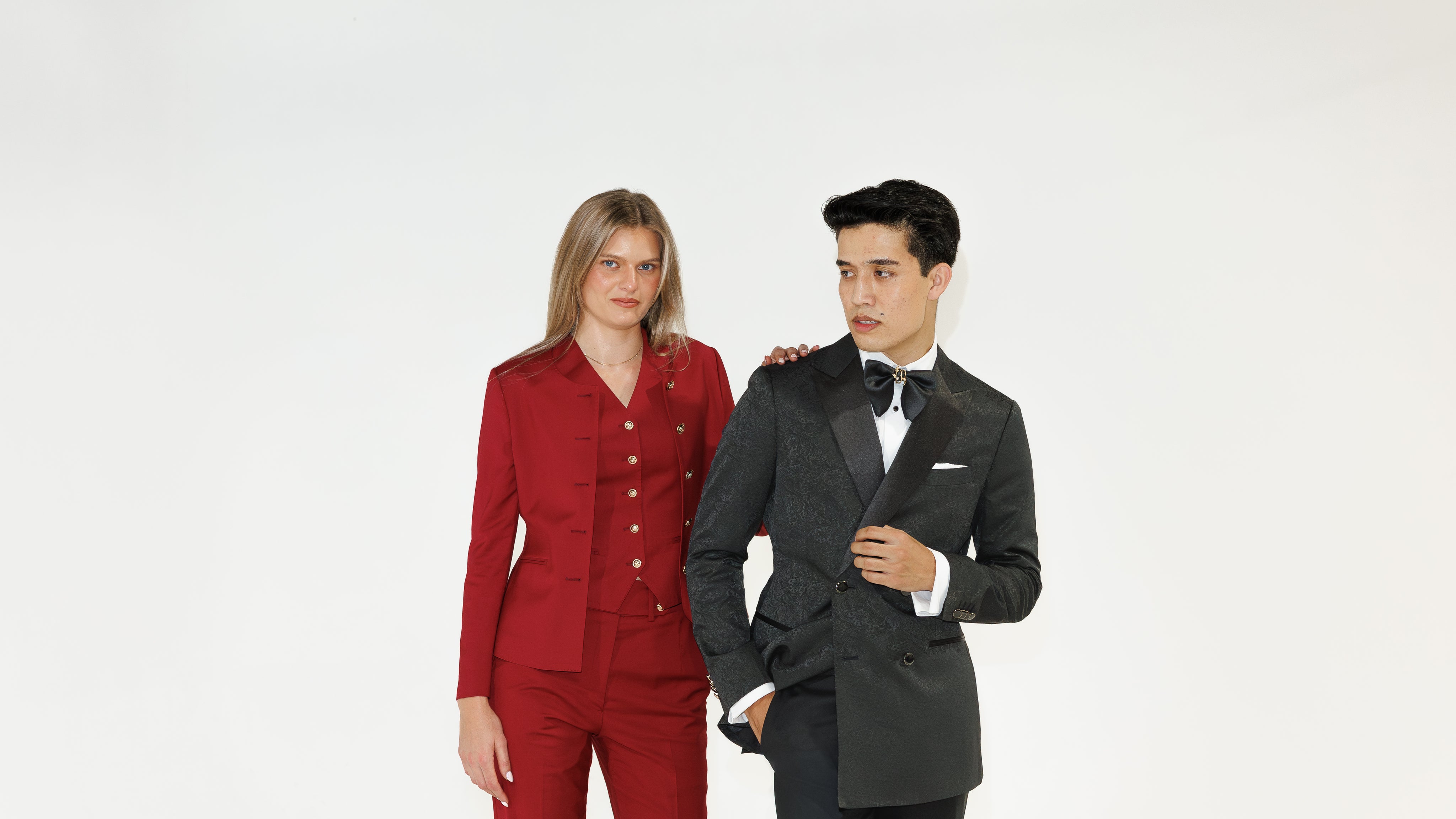 Two people wearing formal attire against a white background