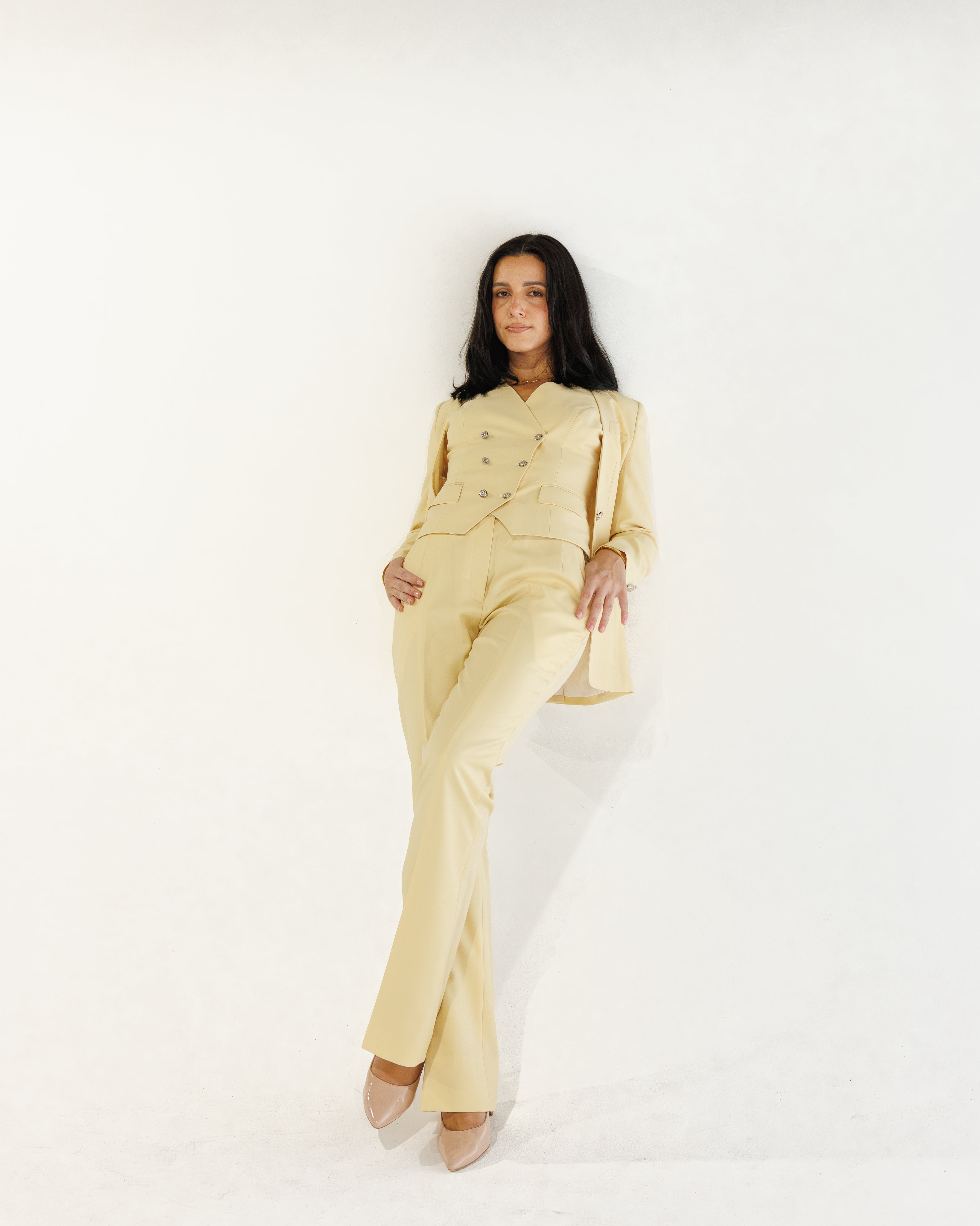 Woman wearing a yellow suit against a white background