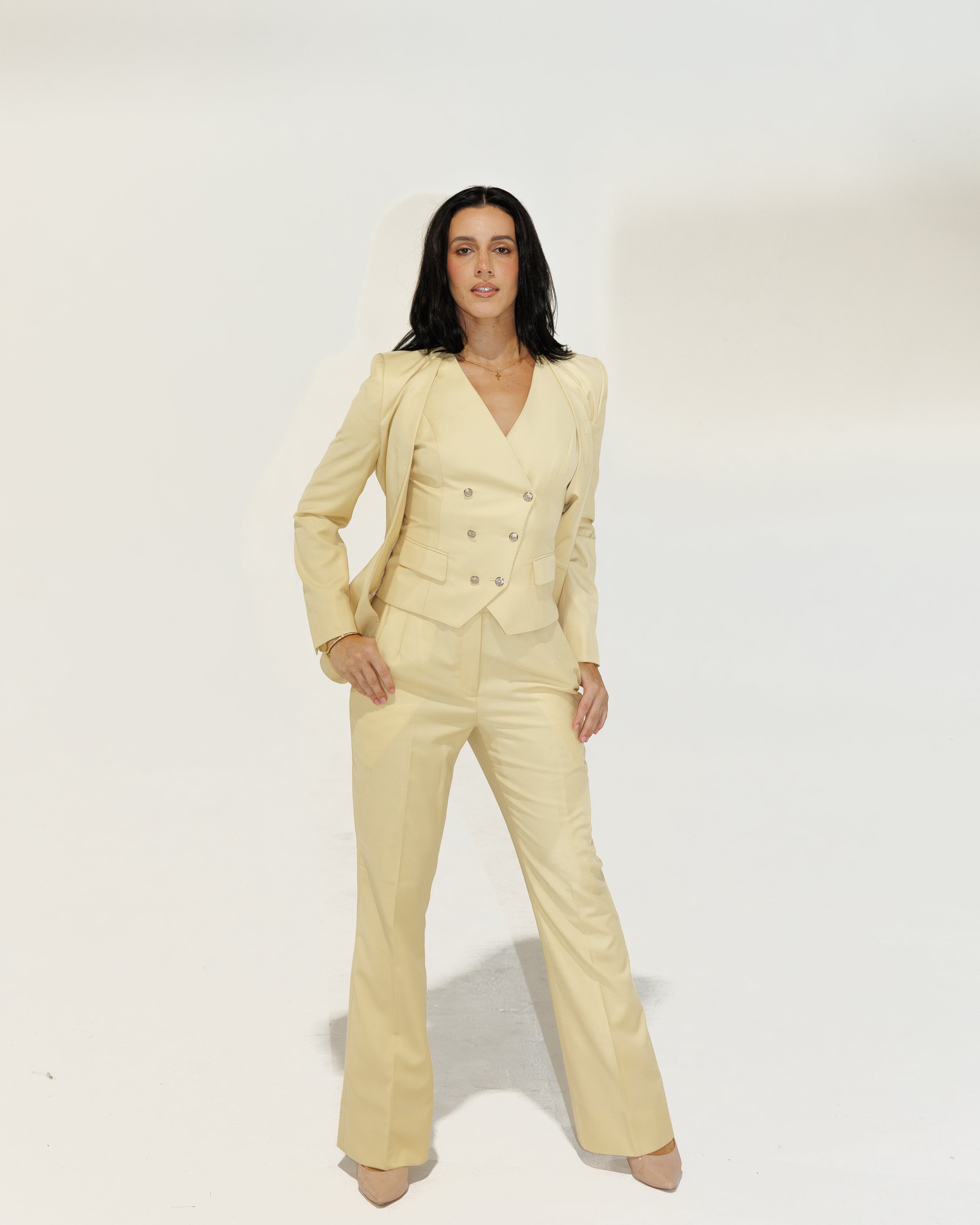 Woman wearing a yellow suit against a white background