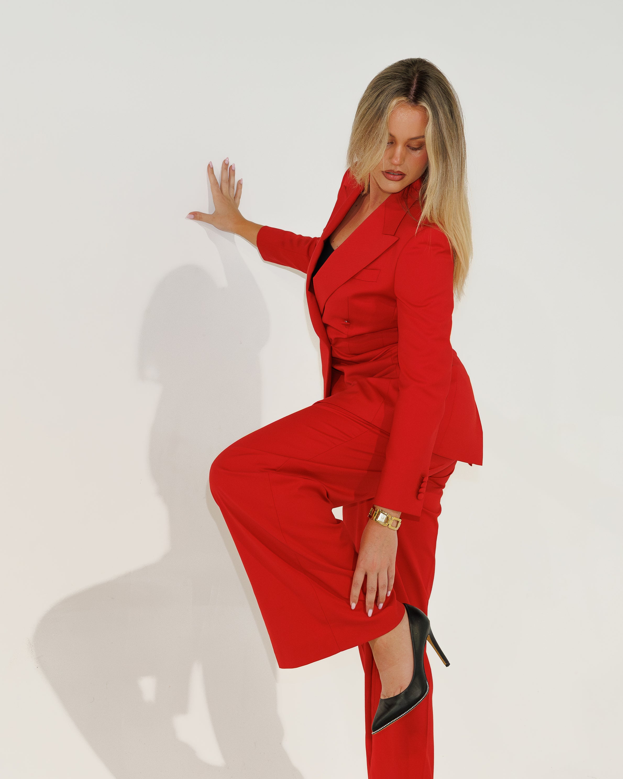 Woman in a red outfit posing against a white background