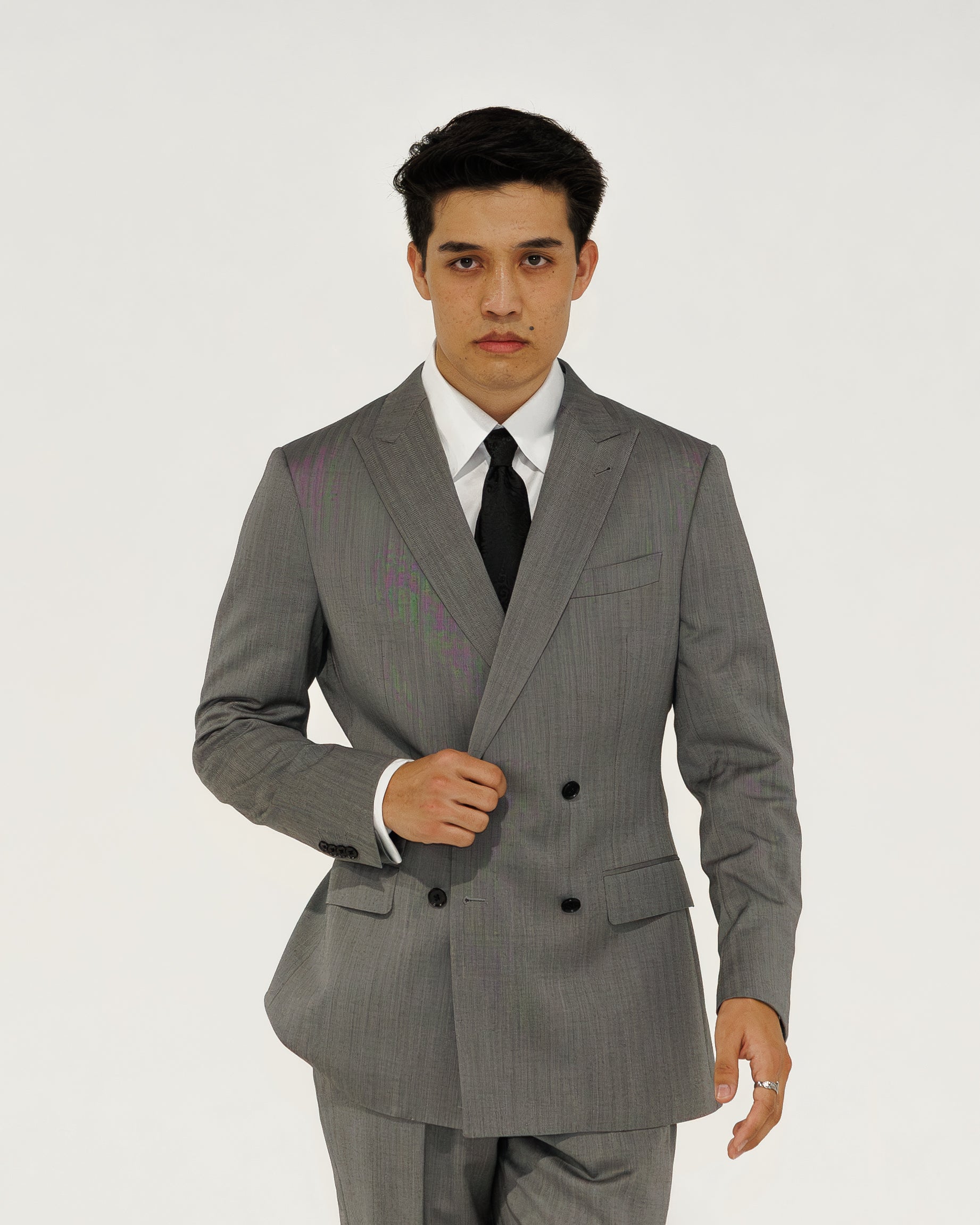 Man wearing a gray suit with a white shirt and black tie on a white background