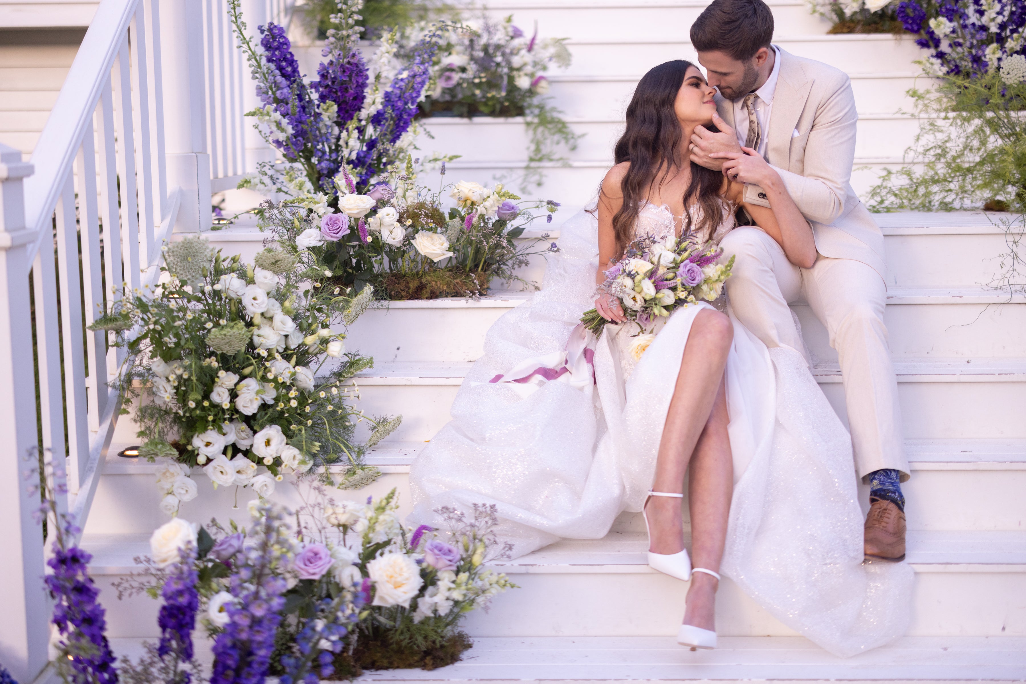 Wedding couple kissing on a staircase with floral decorations