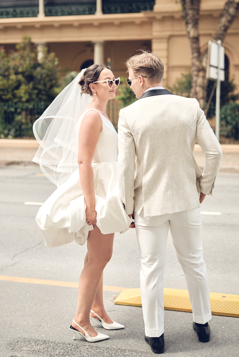 Man and woman in formal attire standing on a street