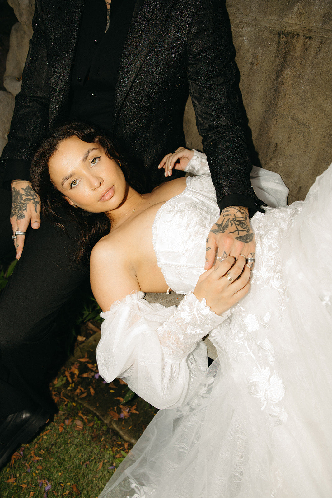 Person in a wedding dress and another person in formal attire, possibly on a wedding day.