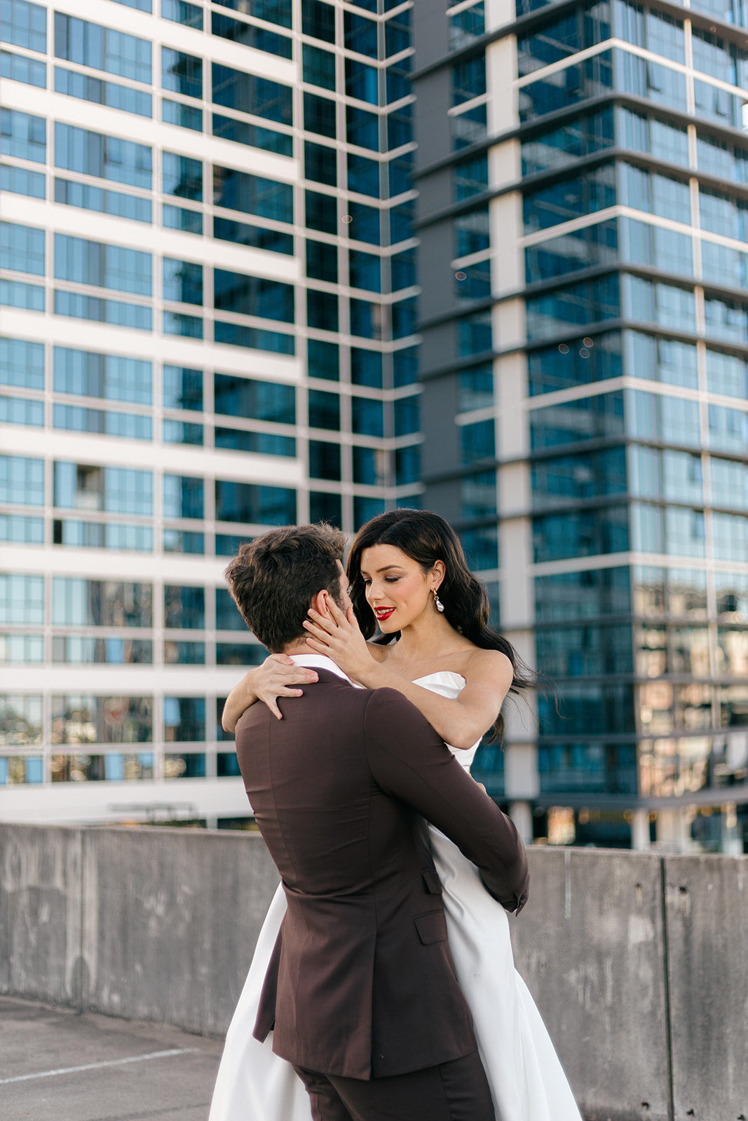 Couple embracing on a rooftop with modern city skyline in the background