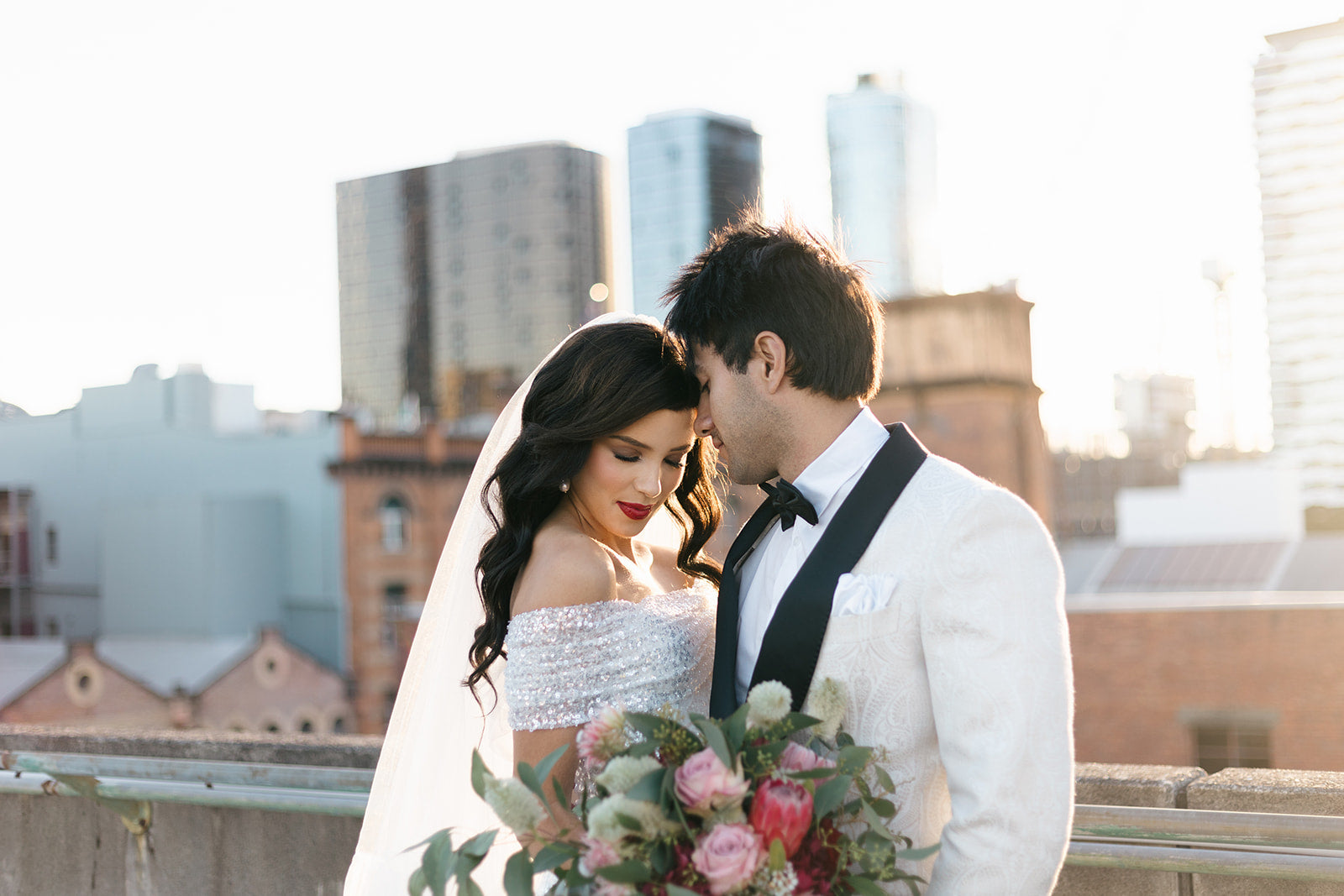Wedding couple on a rooftop with city skyline in the background