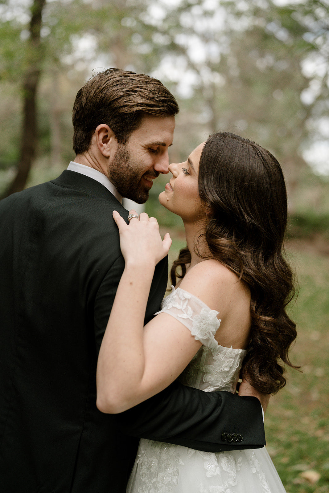 Man and woman embracing outdoors with a blurred natural background
