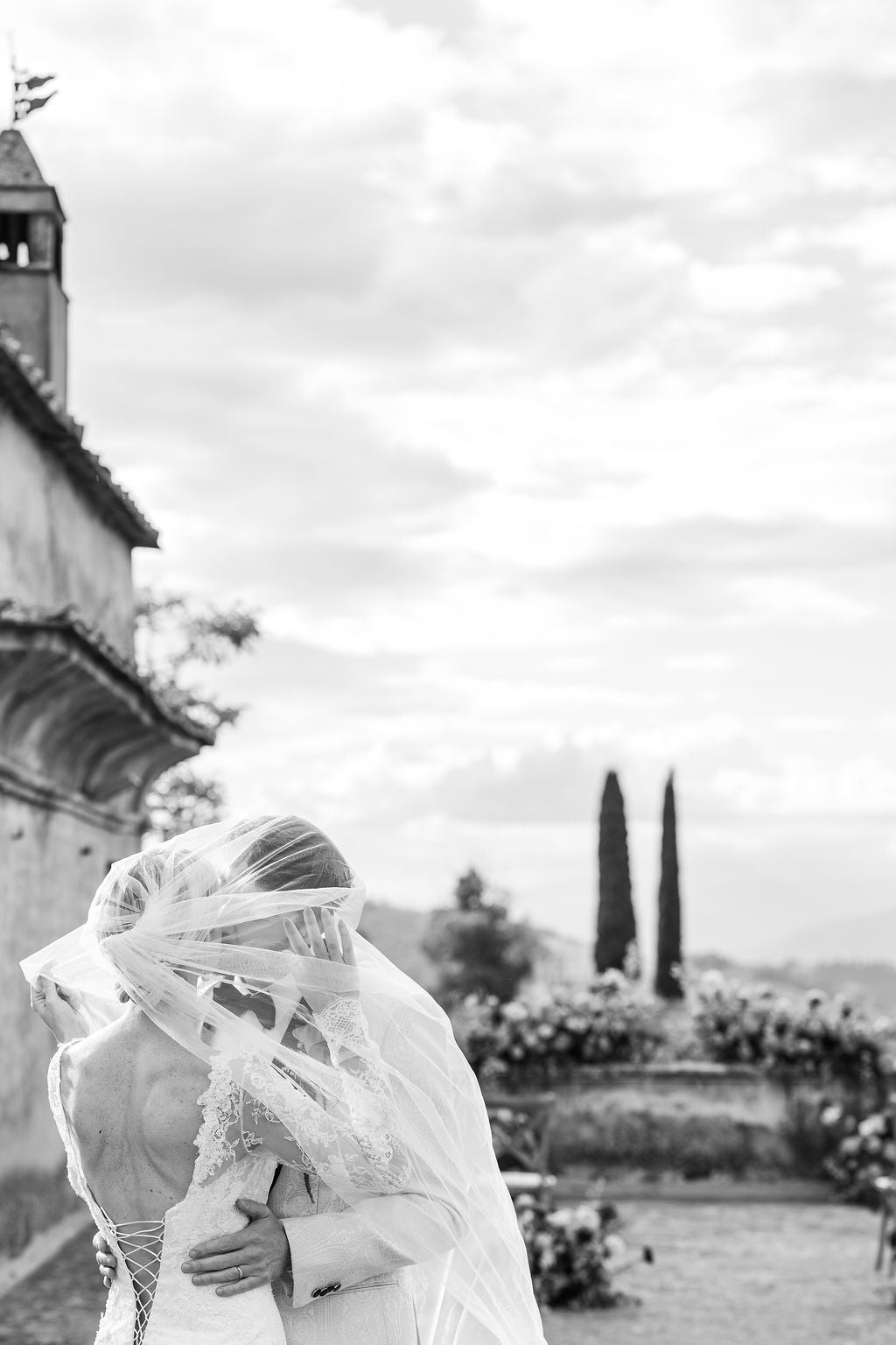 Black and white photo of a couple embracing with a scenic background